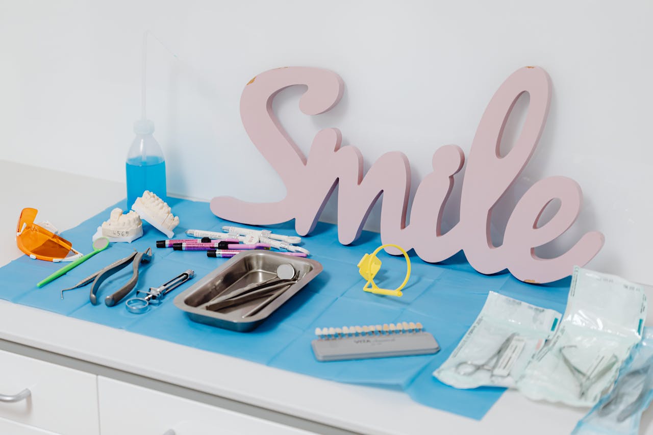 Professional dental tools arranged with a large smile sign in a dental clinic setting.
